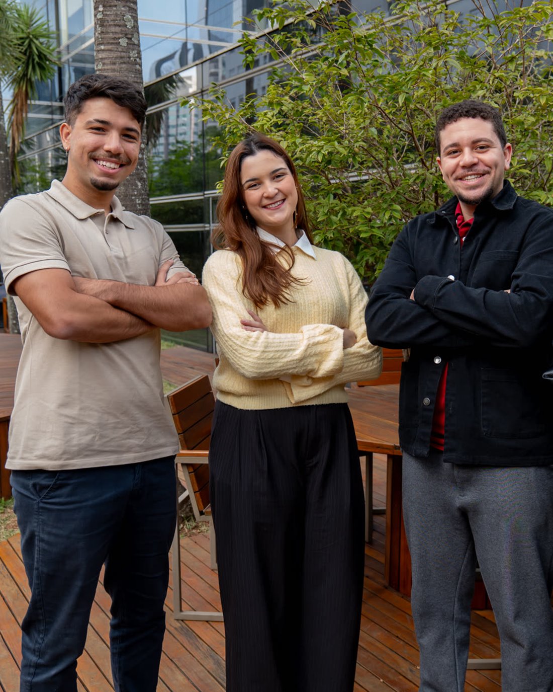 Três estagiários da CTG Brasil no deck ao ar livre da sede